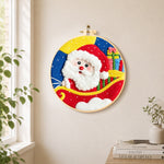 Santa in sleigh with gifts needle felt wall art displayed in a bright home interior