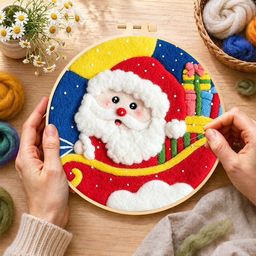 Creating the santa in sleigh with gifts wool painting by hand with a felting needle