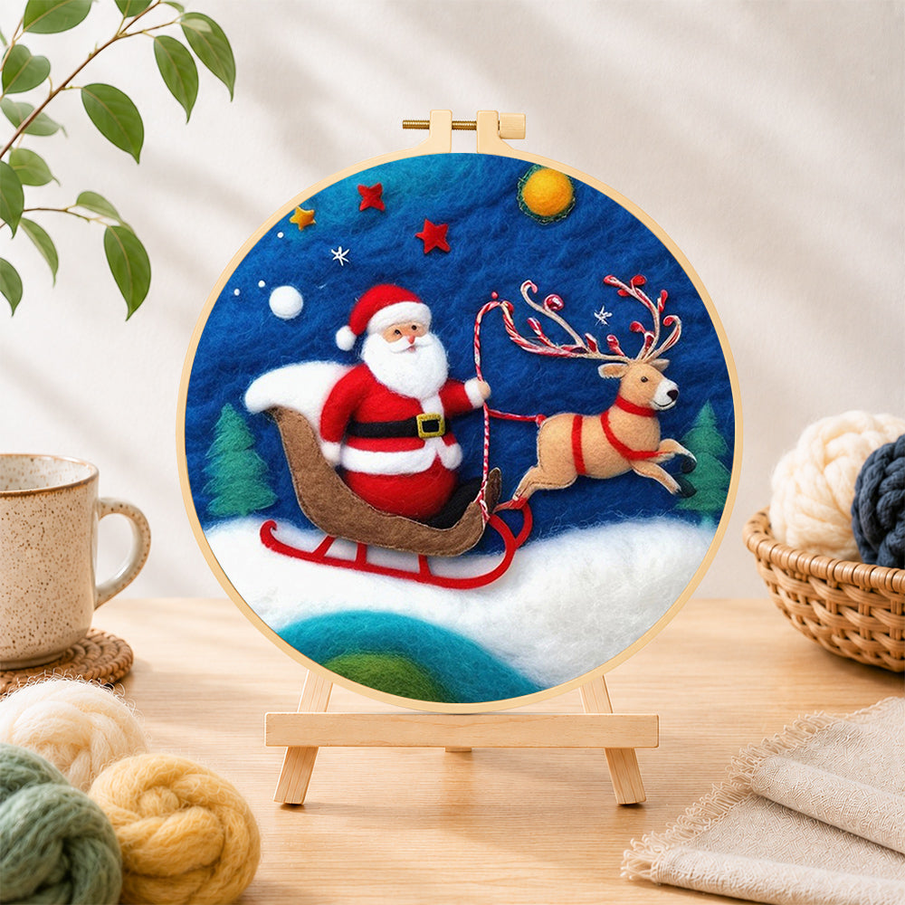 Finished santa in sleigh with reindeer needle felting displayed on a wooden easel