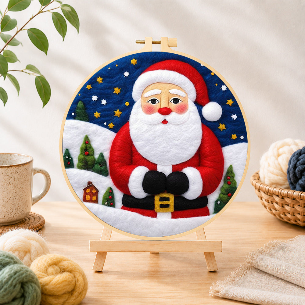 Finished santa with mini village needle felting displayed on a wooden easel