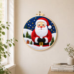 Santa with mini village needle felt wall art displayed in a bright home interior
