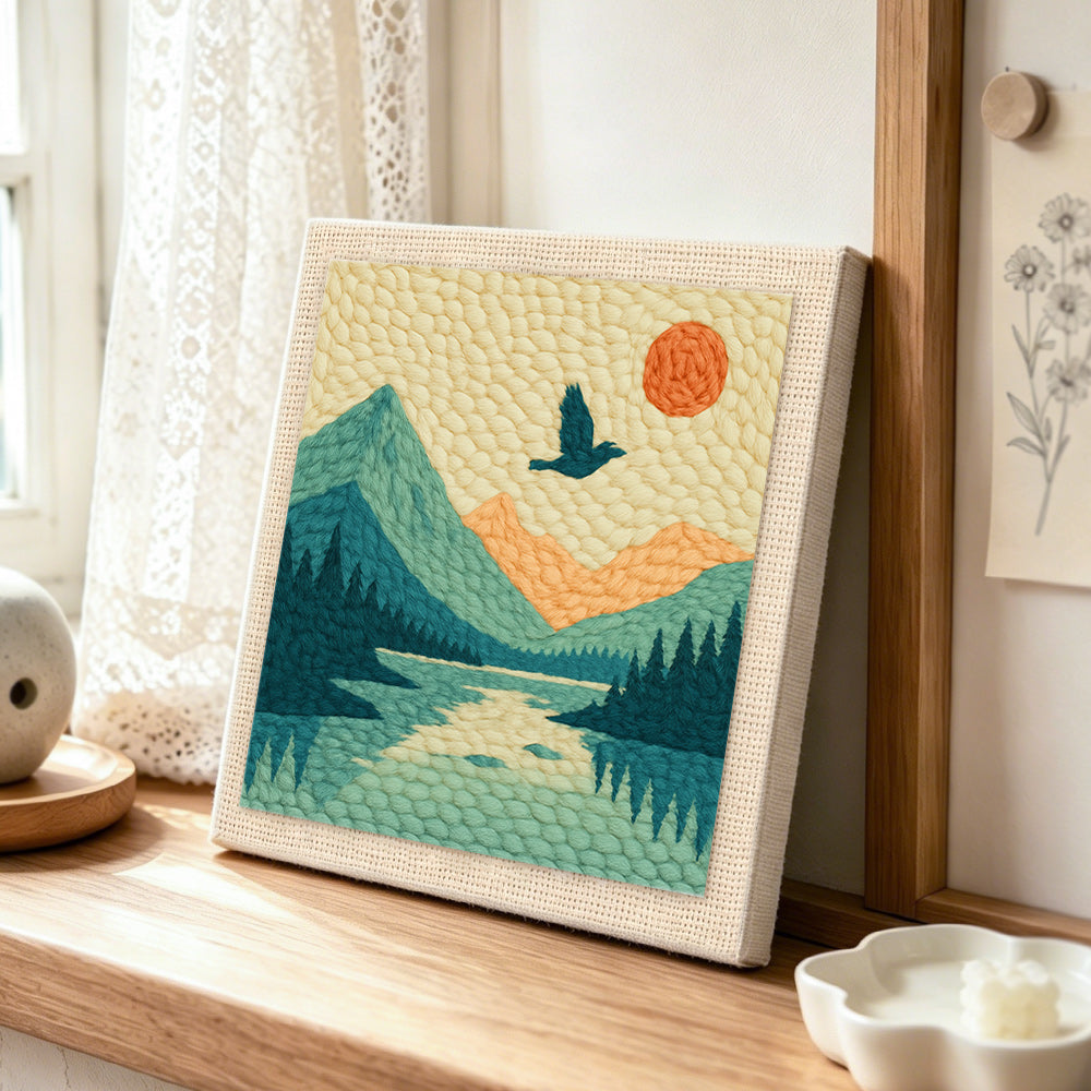 Scenic mountain landscape punch needle artwork displayed on a table