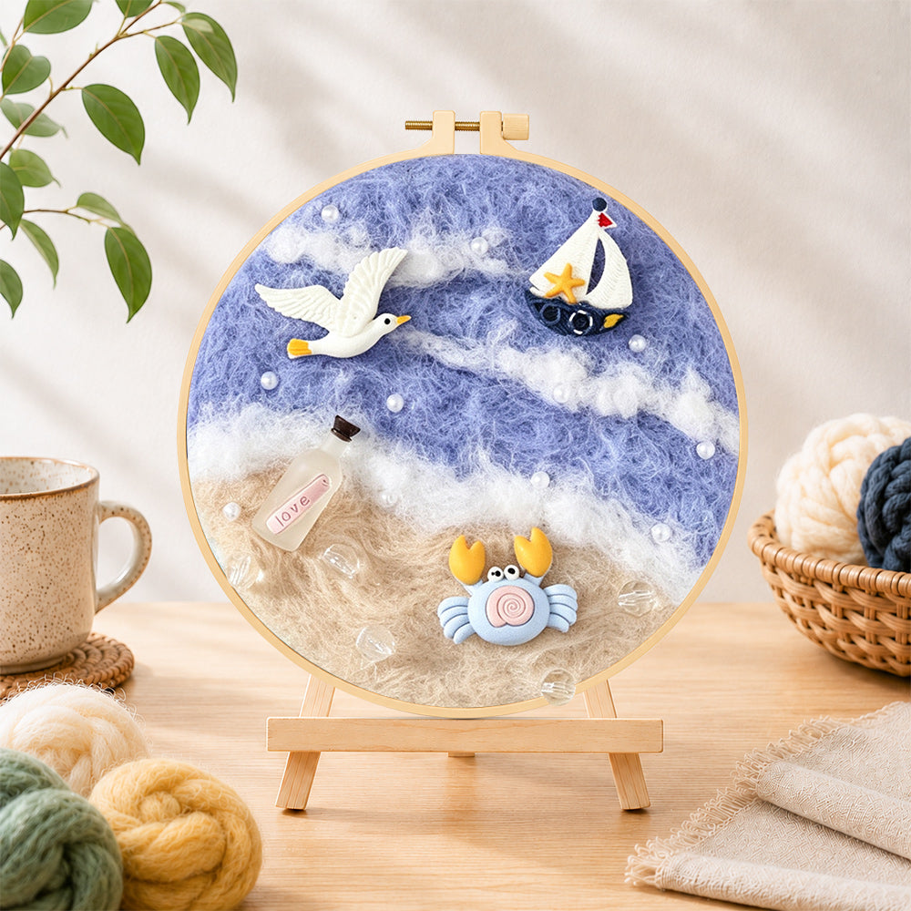 Finished seagull, crab and sailboat needle felting displayed on a wooden easel
