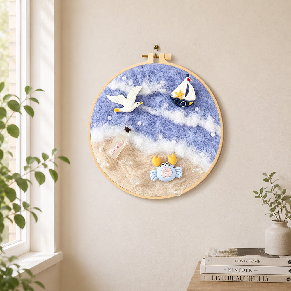 Seagull, crab and sailboat needle felt wall art displayed in a bright home interior