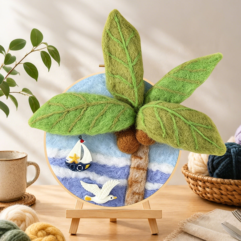 Finished seagull, palm tree and sailboat needle felting displayed on a wooden easel