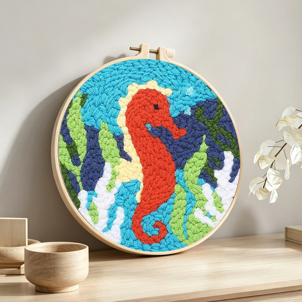 Seahorse and seaweed punch needle artwork displayed on a table