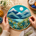 Creating the serene blue mountain with textured floral foliage wool painting by hand with a felting needle