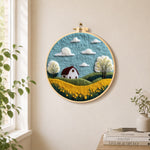 Serene blue sky and golden field needle felt wall art displayed in a bright home interior