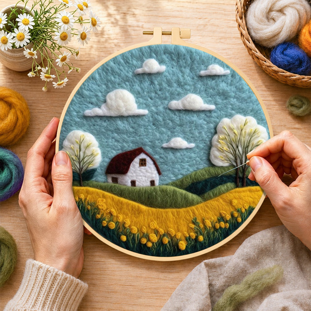 Creating the serene blue sky and golden field wool painting by hand with a felting needle