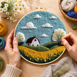 Creating the serene blue sky and golden field wool painting by hand with a felting needle