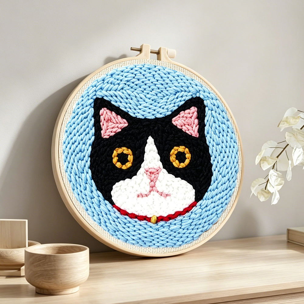 Serious cat punch needle artwork displayed on a table