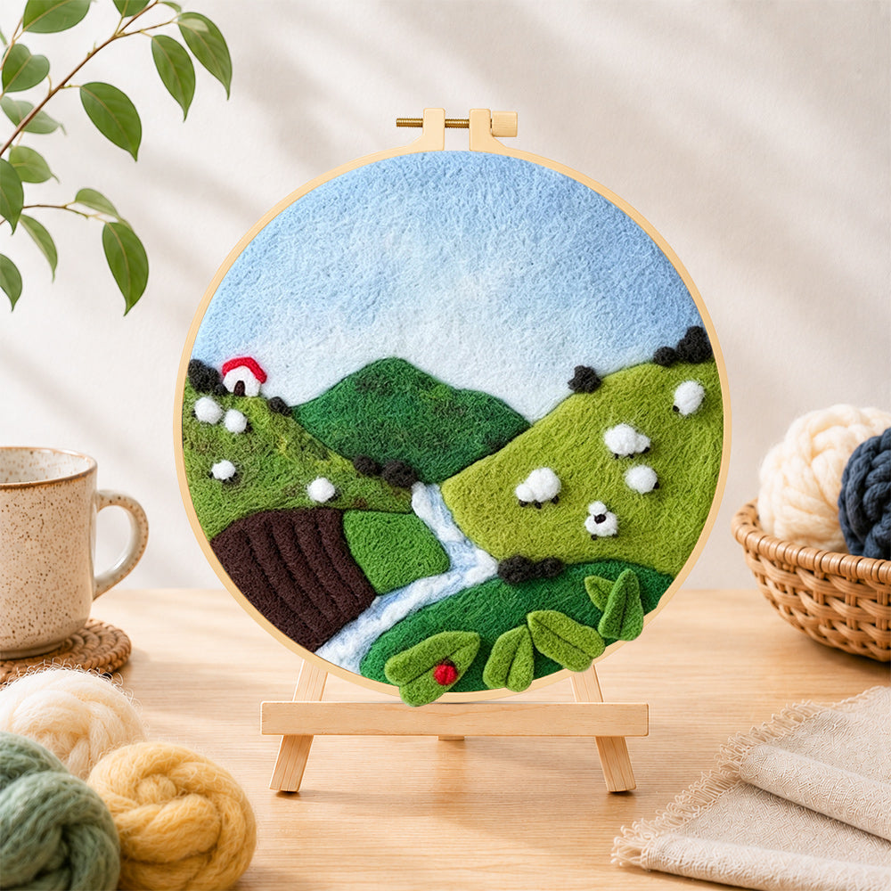 Finished sheep on the green hillside needle felting displayed on a wooden easel