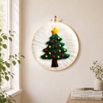 Simple green christmas tree needle felt wall art displayed in a bright home interior