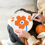 Creating handmade single orange flower punch needle artwork