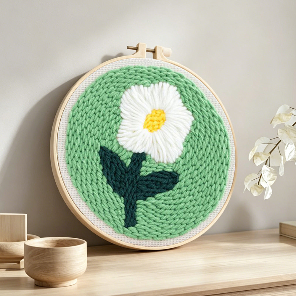 Single white daisy punch needle artwork displayed on a table