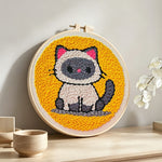 Sitting kitten punch needle artwork displayed on a table