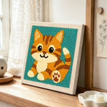 Sitting orange tabby cat punch needle artwork displayed on a table