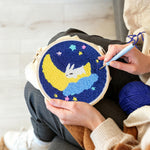 Creating handmade sleeping bunny on crescent moon and stars punch needle artwork