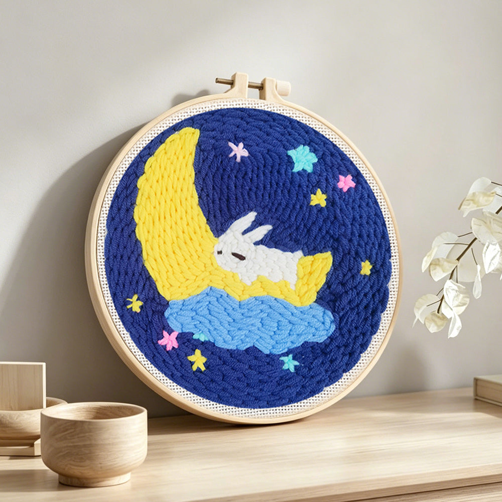 Sleeping bunny on crescent moon and stars punch needle artwork displayed on a table
