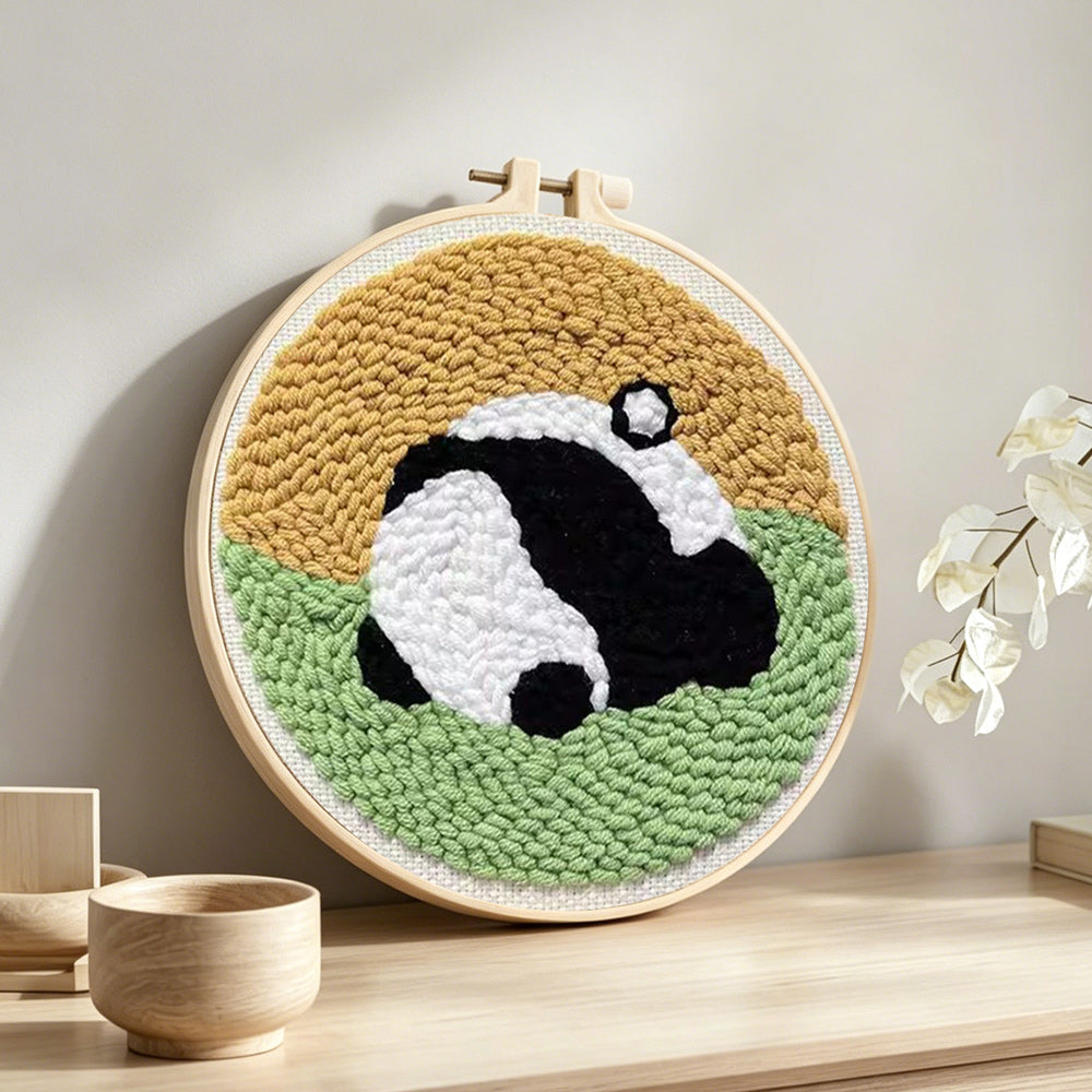 Sleeping curled panda punch needle artwork displayed on a table