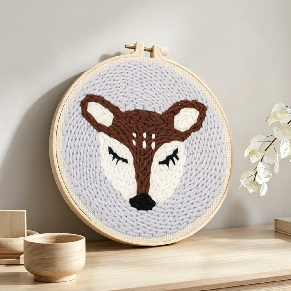 Sleeping deer punch needle artwork displayed on a table
