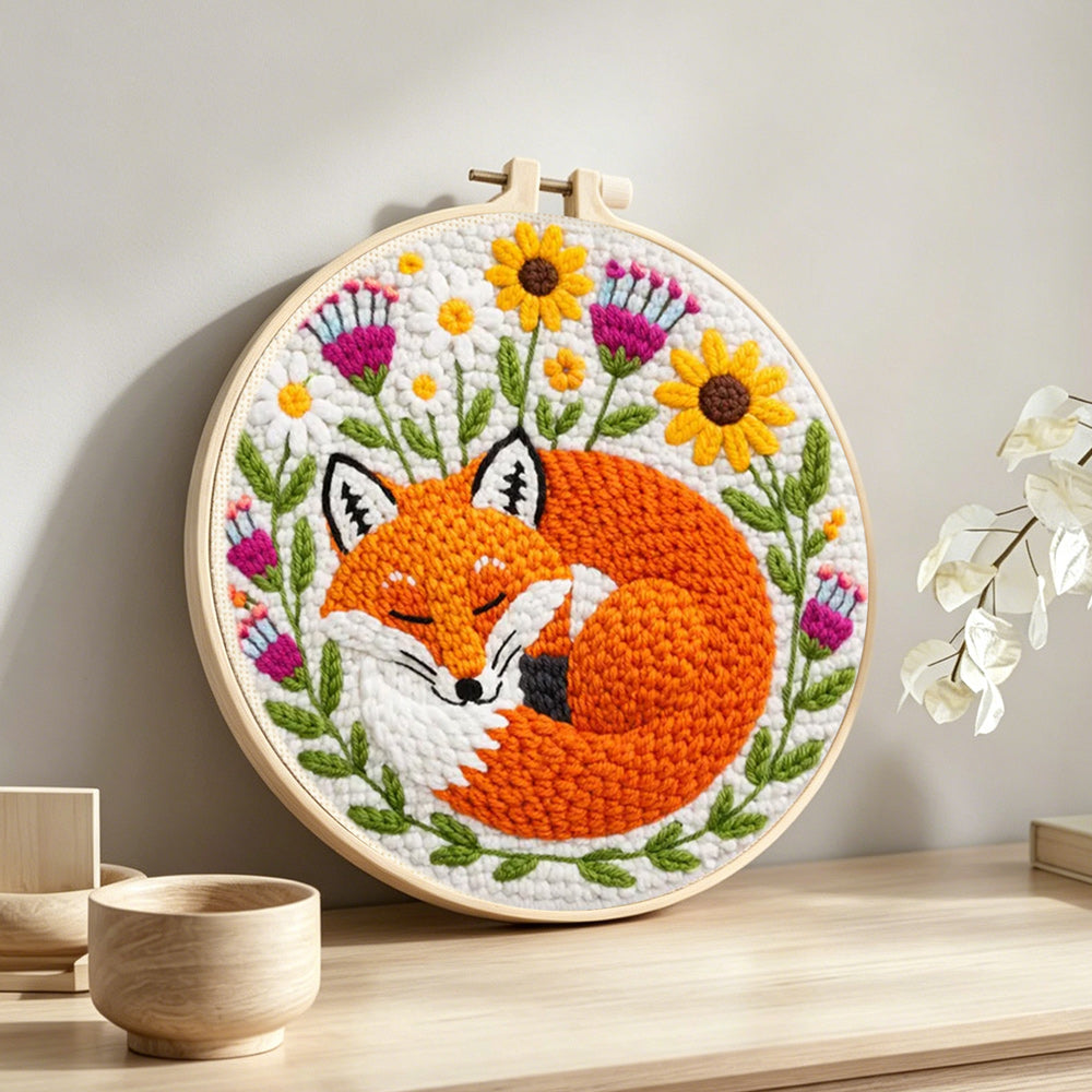 Sleeping fox among the flowers punch needle artwork displayed on a table