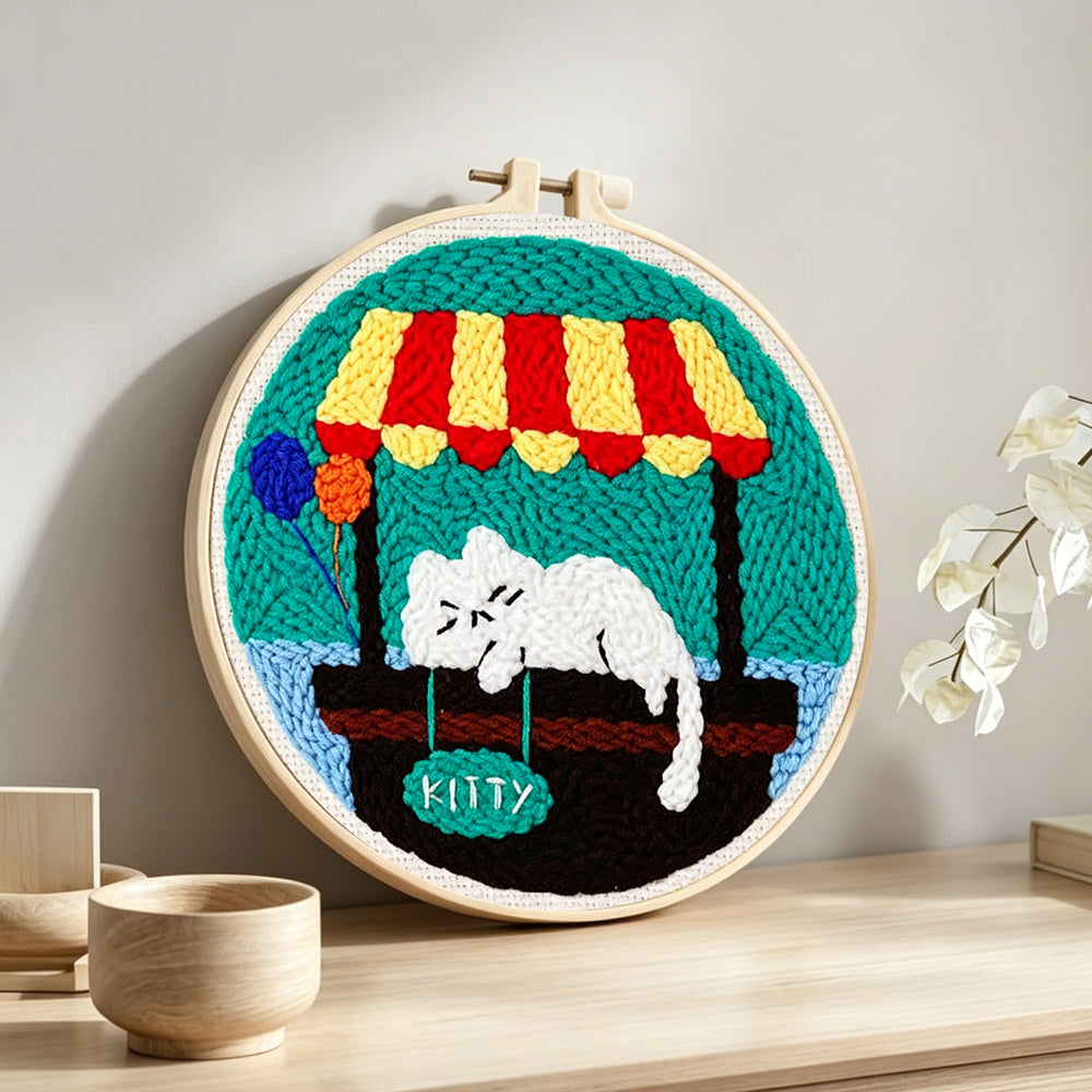 Sleeping white cat punch needle artwork displayed on a table
