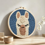 Sleepy alpaca punch needle artwork displayed on a table
