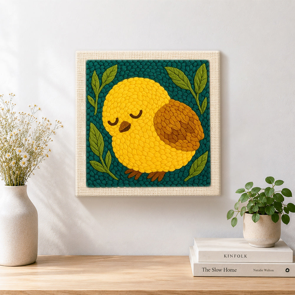 Finished sleepy yellow bird artwork displayed on a wall