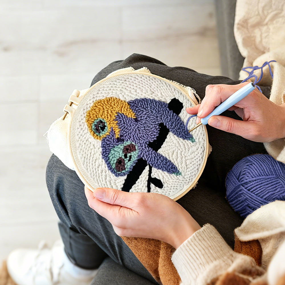 Creating handmade sloths resting on tree branch punch needle artwork