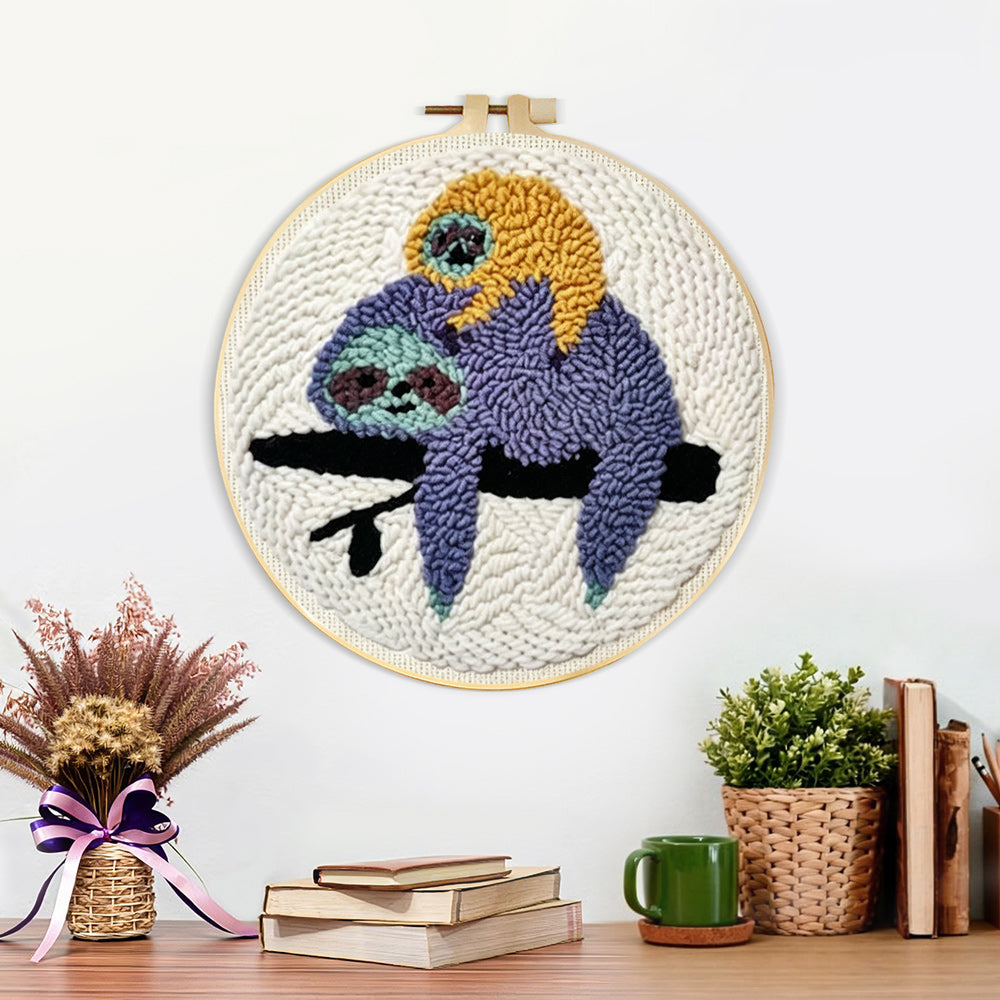 Finished sloths resting on tree branch artwork displayed on a wall