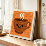 Smiley face coffee cup punch needle artwork displayed on a table
