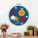 Finished smiley orange with "best of luck" text artwork displayed on a wall