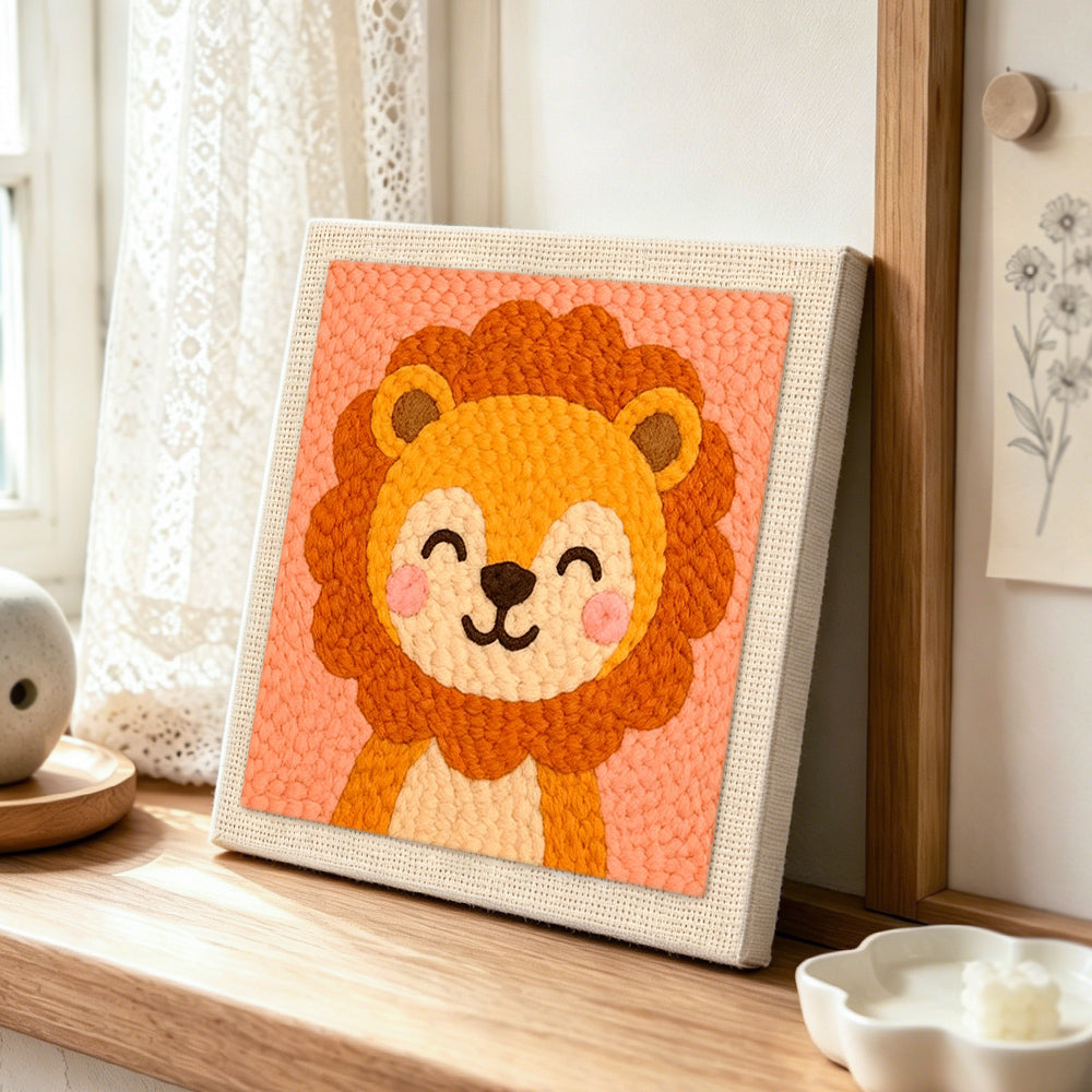 Smiling baby lion punch needle artwork displayed on a table