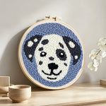 Smiling dog punch needle artwork displayed on a table