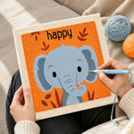 Creating handmade smiling grey elephant punch needle artwork