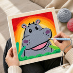 Creating handmade smiling grey hippo with rainbow sunset punch needle artwork