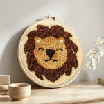 Smiling lion punch needle artwork displayed on a table