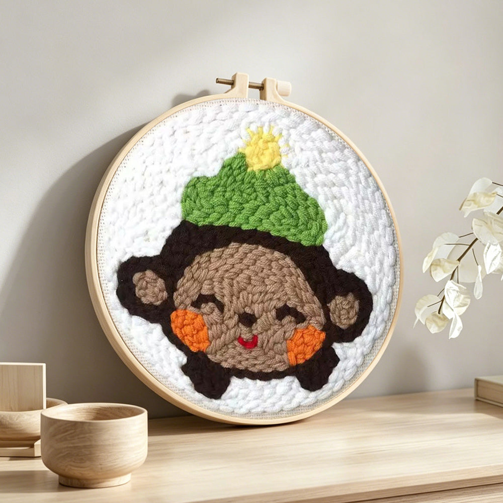 Smiling little monkey punch needle artwork displayed on a table