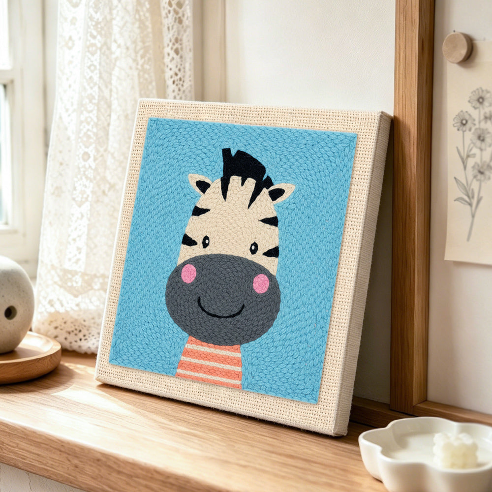 Smiling zebra head punch needle artwork displayed on a table