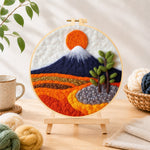 Finished snow-capped mountain at sunrise needle felting displayed on a wooden easel