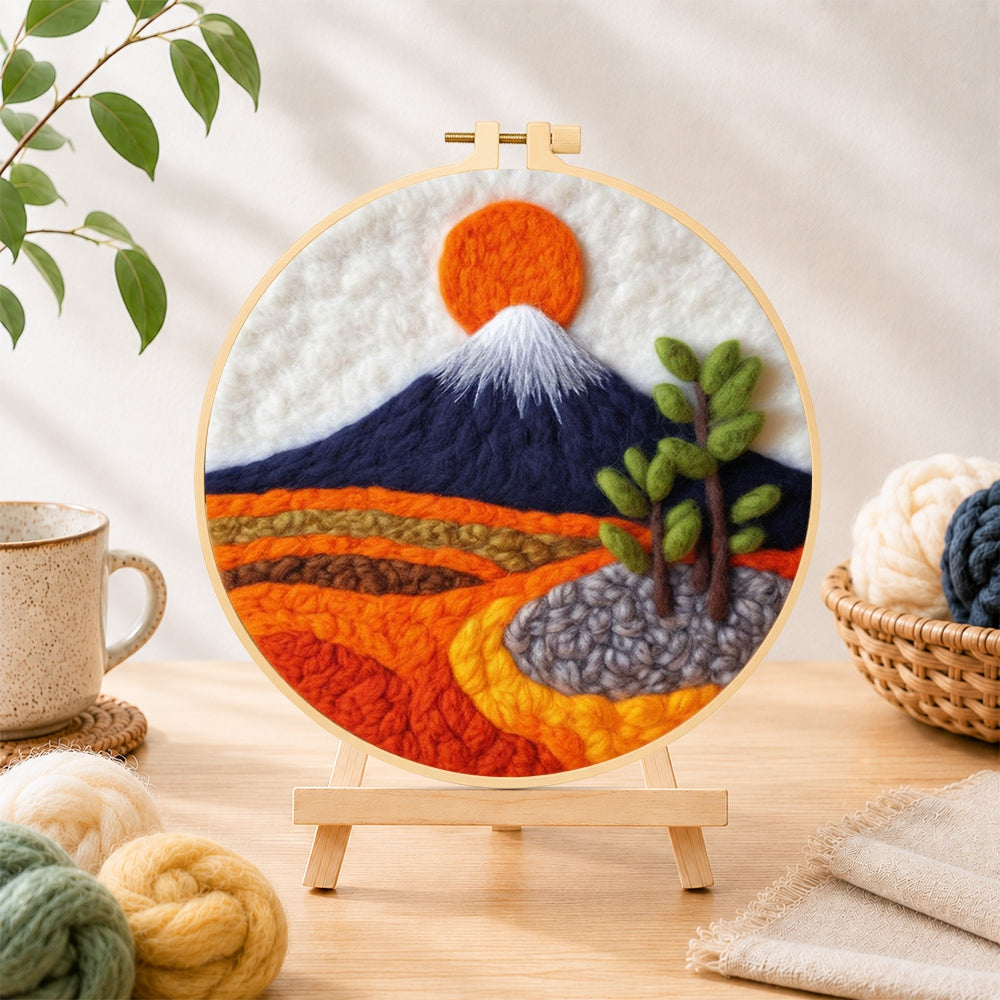 Finished snow-capped mountain at sunrise needle felting displayed on a wooden easel
