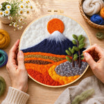 Creating the snow-capped mountain at sunrise wool painting by hand with a felting needle