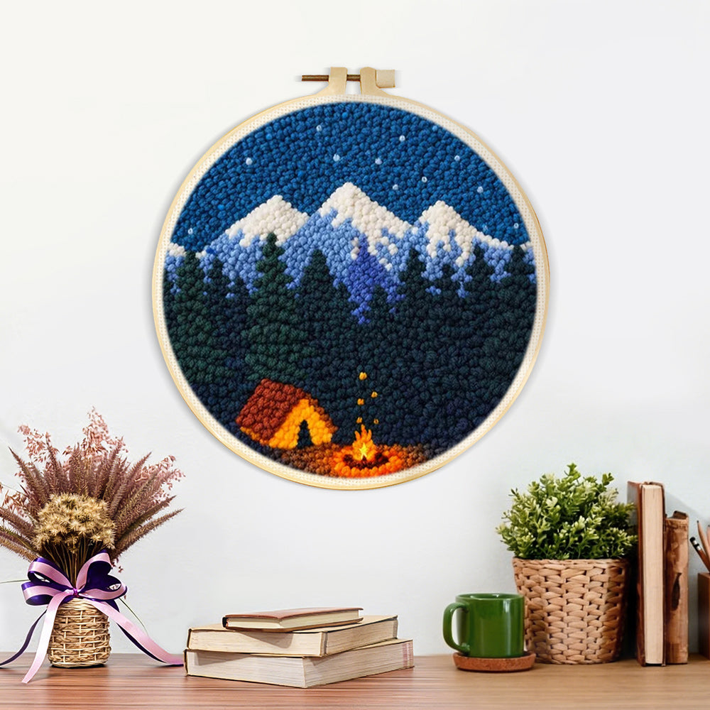 Finished snow-capped mountains, dark forest and campfire artwork displayed on a wall