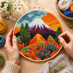Creating the snow-capped volcano and lush plants wool painting by hand with a felting needle