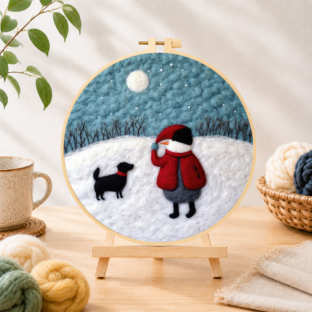 Finished snowman and black dog in the snow needle felting displayed on a wooden easel