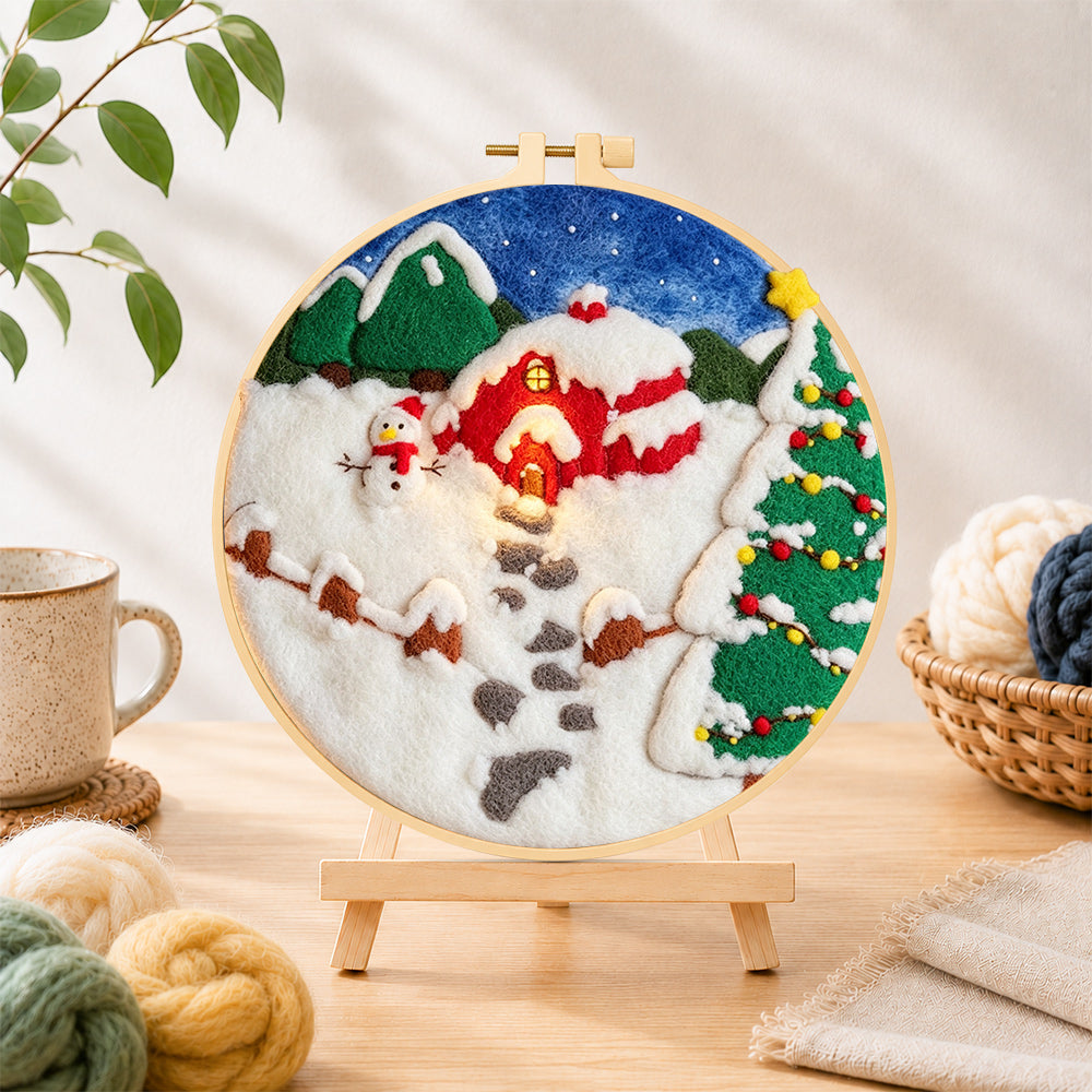 Finished snowman and christmas tree red cabin needle felting displayed on a wooden easel