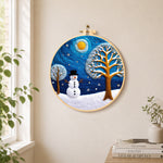 Snowman and frosted tree under the night sky needle felt wall art displayed in a bright home interior