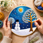 Creating the snowman and frosted tree under the night sky wool painting by hand with a felting needle