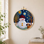 Snowman and loyal dog friend needle felt wall art displayed in a bright home interior